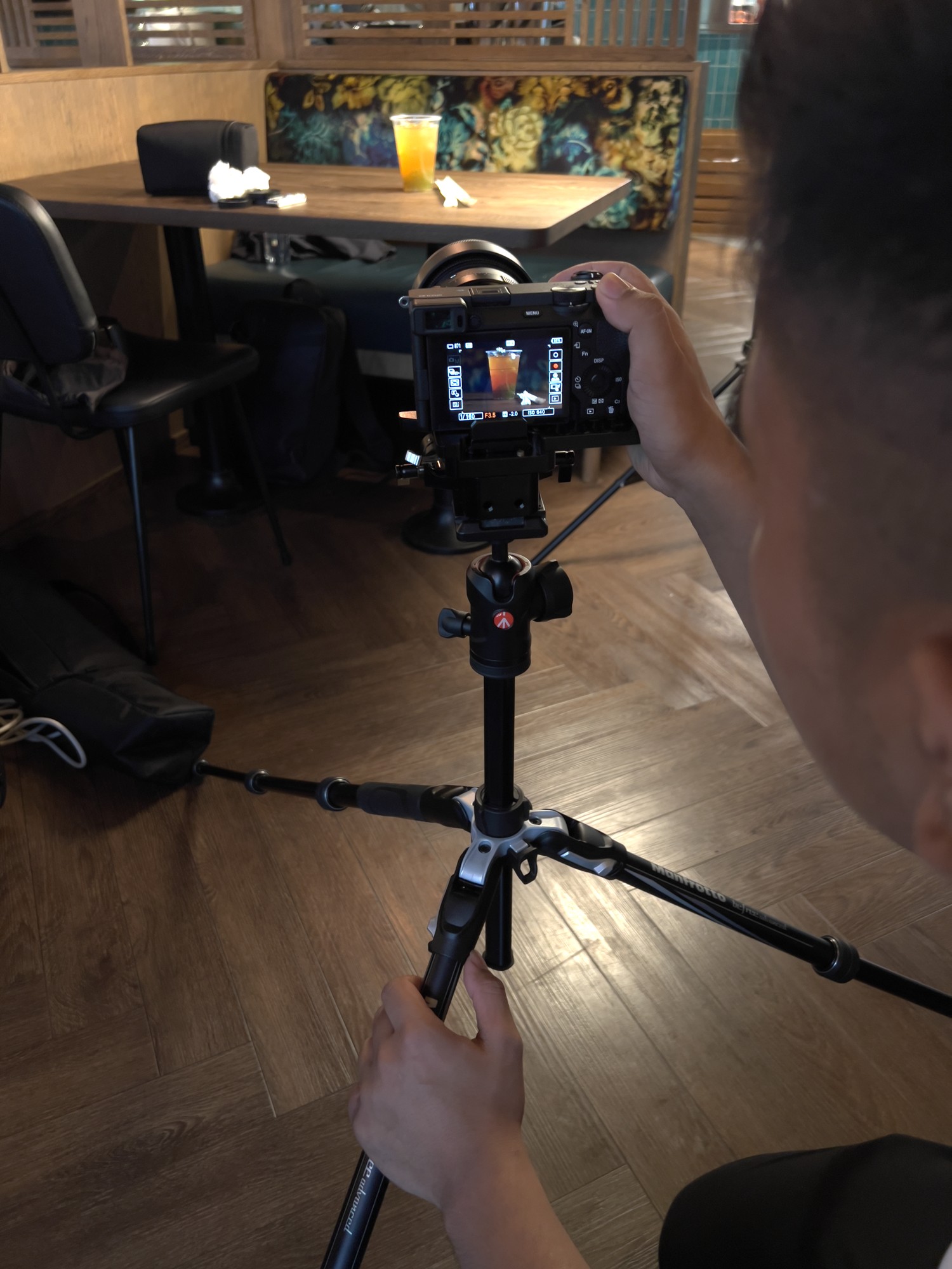 Camera crew framing a drink with a tripod-mounted camera inside YIPS Stavanger